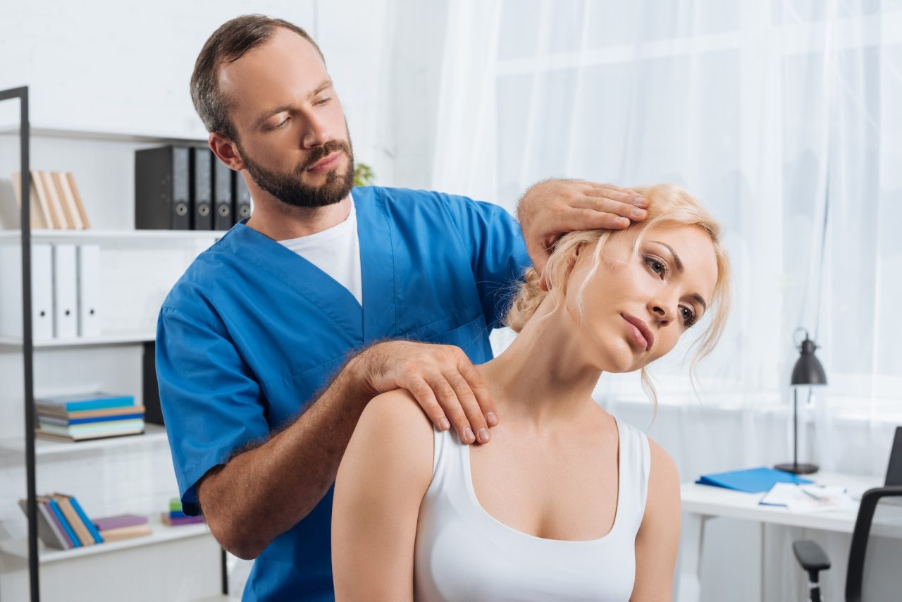 Physiotherapist treating a patient neck in hospital